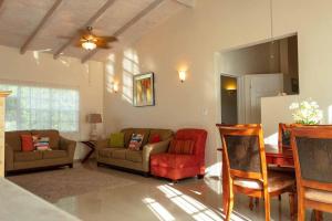 a living room with couches and chairs and a mirror at Sugarfields Villa in Jolly Harbour