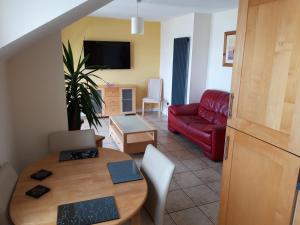 a living room with a table and a red couch at Beautiful Seaview Penthouse Apartment in Bundoran