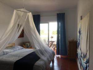 - une chambre avec un lit et une moustiquaire dans l'établissement Green Elephant Place, à Carvoeiro
