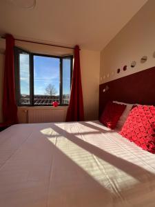 - une chambre avec un grand lit et une fenêtre dans l'établissement Le Vinois, à Caillac