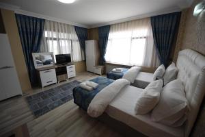 a living room with a white couch and a television at Hotel Selimpaşa Konağı in Silivri