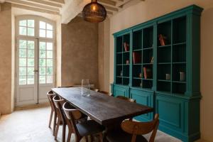 une salle à manger avec une table et des chaises en bois dans l'établissement Private Mansion, completely renovated with swimming pool, in historical center, à Arles