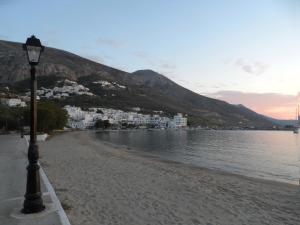 a street light on a sandy beach next to the water at Amorgi Studios in Aegiali