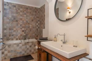 une salle de bain avec un lavabo, une baignoire et un miroir dans l'établissement Private Mansion, completely renovated with swimming pool, in historical center, à Arles 40 autres photos