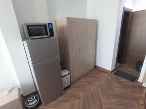 a room with a refrigerator with a tv on top at Mini Loft in Becerril de la Sierra