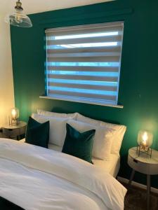 a bedroom with a white bed with a green wall at Chester's Retreat in Belton