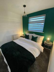 1 dormitorio con 1 cama grande y pared verde en Chester's Retreat en Belton