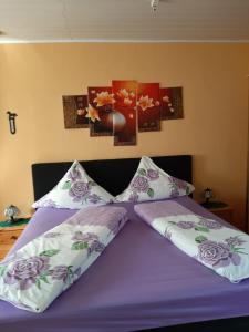 a bed with purple sheets and pillows on it at Ferienwohnung Röbel/Müritz in Röbel