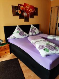 a bedroom with a bed with purple sheets and pillows at Ferienwohnung Röbel/Müritz in Röbel