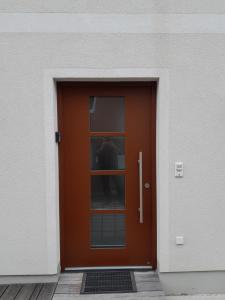 eine braune Tür mit einem Fenster auf einem Gebäude in der Unterkunft Vor den Toren Salzburgs in Wals