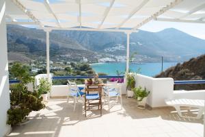 eine Terrasse mit einem Tisch und Stühlen sowie Aussicht in der Unterkunft Amorgi Studios in Aegiali