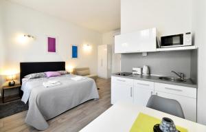 a bedroom with a large bed and a kitchen at Deluxe Apartments Ria in Zagreb