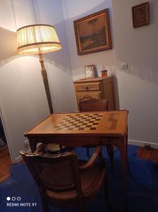 a room with a chessboard on a table with a lamp at La petite maison du Quai in Blois