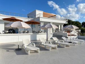 a group of chairs and umbrellas on a patio at Villa Perla in Utjeha