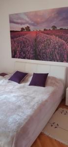 a bedroom with a painting of a field of flowers at Apartmani Amira Trebinje in Trebinje +26 photos