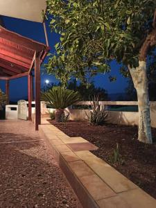 Una pasarela frente a una casa por la noche en Green Garden House en Stóloi