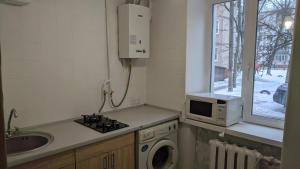 a kitchen with a washing machine and a microwave at Apartments near the Trinity Church on Dovzhenko Street,102 in Chernihiv +22 photos