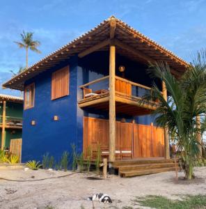 a blue house with a balcony on the beach at Vila Budião - Corumbau in Corumbau