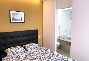 - une chambre avec un lit doté d'une tête de lit noire et d'un lavabo dans l'établissement Casa Miradouro Apartments, à Setúbal