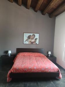 um quarto com uma cama vermelha e uma fotografia na parede em Casa Vacanze A Truatura em Ragusa