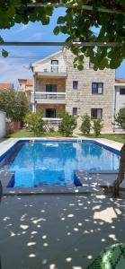a large blue swimming pool in front of a building at Apartmani Amira Trebinje in Trebinje