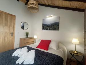 um quarto com uma cama com almofadas vermelhas e brancas em Casa Ribeiro em Sabugueiro