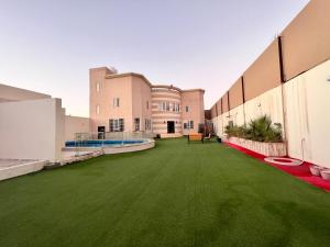 an empty courtyard of a building with green grass at فيلا كارمة in Al Madinah
