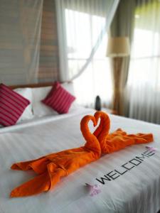 dois cisnes feitos de toalhas numa cama em Marind Dive Eco Resort em Waha