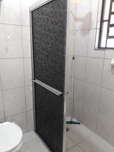 a shower door in a bathroom with a toilet at Chácara Terra Boa in Extrema