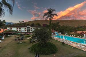 a view of a resort with a pool and a palm tree at Resort Fazenda 3 Pinheiros in Engenheiro Passos