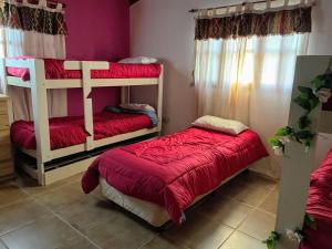 1 dormitorio con 2 literas con sábanas rojas en RIBERAS DEL RÍO en Oliveros