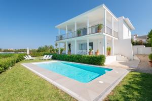 a villa with a swimming pool in front of a house at NEW! Villa ESPERANZA, Can Marilla, Front Sea View, Pool, AC, BBQ in Portocolom