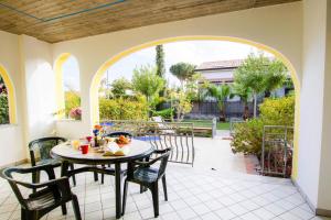 una mesa y sillas en un patio con un arco en Apartment in Cilento near Sandy Beach, en Castellammare di Velia 4 fotos más