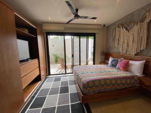 una camera con letto, TV e balcone di Zen Tulum a Tulum