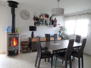 a dining room with a table and a wood stove at Holiday home, Frehel in Fréhel