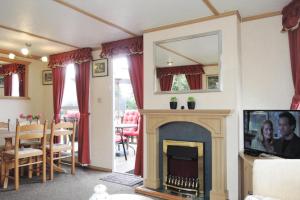 a living room with a fireplace and a mirror at Mobile home in Kolczewo at a lake in Kołczewo