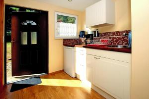 a kitchen with white cabinets and a black door at Holiday Village on the Vineyard, Dobbrikow in Dobbrikow