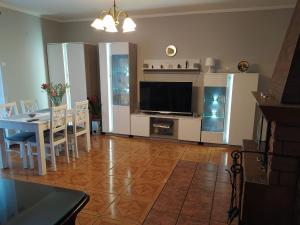 a living room with a dining table and a television at Holiday house with swimming pool in Morzyczyn in Morzyczyn