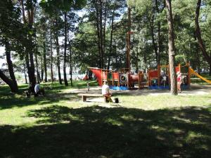 people in a park with a bench and a playground at Holiday house with swimming pool in Morzyczyn in Morzyczyn
