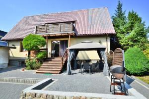 a house with an umbrella and a table and chairs at holiday home, Kolobrzeg in Kołobrzeg