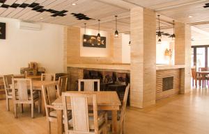 a dining room with tables and chairs and a fireplace at Core Hotel Benoa in Nusa Dua