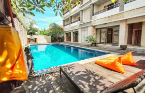 a swimming pool in front of a building at Core Hotel Benoa in Nusa Dua