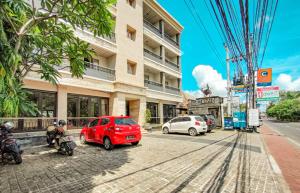 un coche rojo estacionado frente a un edificio en Core Hotel Benoa en Nusa Dua