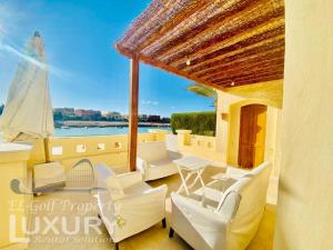 a patio with white chairs and a view of the water at Private Villa Y51 - 3 BedRooms at El-Gouna in Hurghada