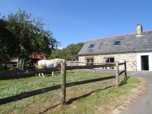ein Pferd stand hinter einem Zaun vor einem Haus in der Unterkunft Country House near Mont St Michel in Saint-Osvin