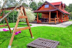 a wooden cabin with a playground in the yard at holiday home, Miedzyzdroje in Międzyzdroje