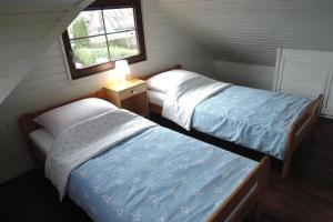 two beds in a small room with a window at holiday home, Miedzyzdroje in Międzyzdroje