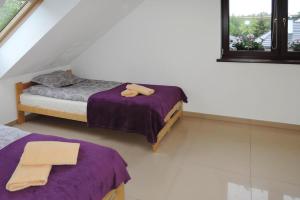 two beds in a room with purple sheets at House in Wolin near Stettiner Haff Lake in Wolin