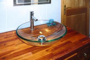a bathroom sink with a glass bowl on a wooden counter at Stone House in Cleder near Sandy Beach in Cléder +19 photos