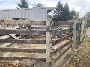 a wooden fence with a sign on it at The Treehut in Ohauiti